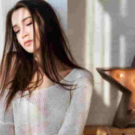 sad lady beside a lighted decorative star