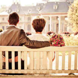 couple on park bench arms around each other